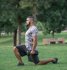 Goal_BCS_Weight_Lunge_B Finishing a weighted lunge exercise in a park