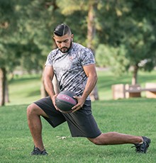 Goal_BCS_Torso_Rot_A Starting a torso rotation with medicine ball exercise in a park