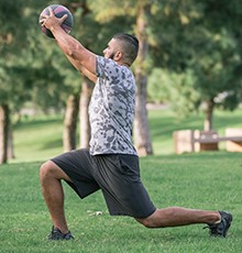 Goal_BCS_Torso_Rot_B Finishing a torso rotation with medicine ball exercise in a park