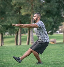Goal_BCS_Side_Hop_A Starting a leg squat to heel exercise in a park