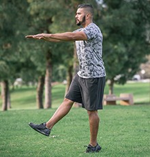 Goal_BCS_Side_Hop_B Finishing a leg squat to heel exercise in a park