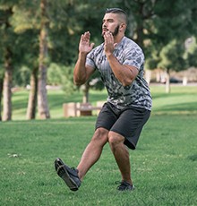 Goal_BCS_Single_Leg_Heel_A Starting a side hop to single leg squat exercise in a park