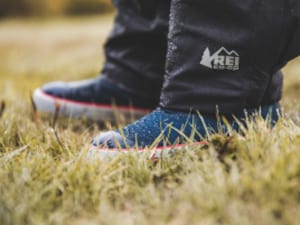 A close-up of kids' shoes on a grassy field.