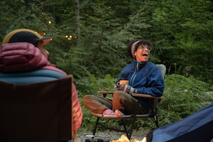 Campers lounging and wearing fleece at campsite