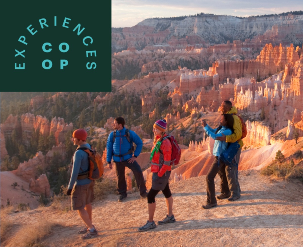 Hikers watching the sun rise over Bryce Canyon.