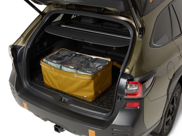 Studio shot of a vehicle with a gear bin in its trunk. Inside the gear bin are smaller gear cubes.