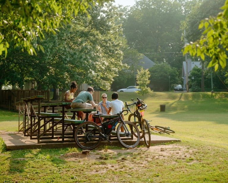 People gathered on bleachers in a city park with bikes.