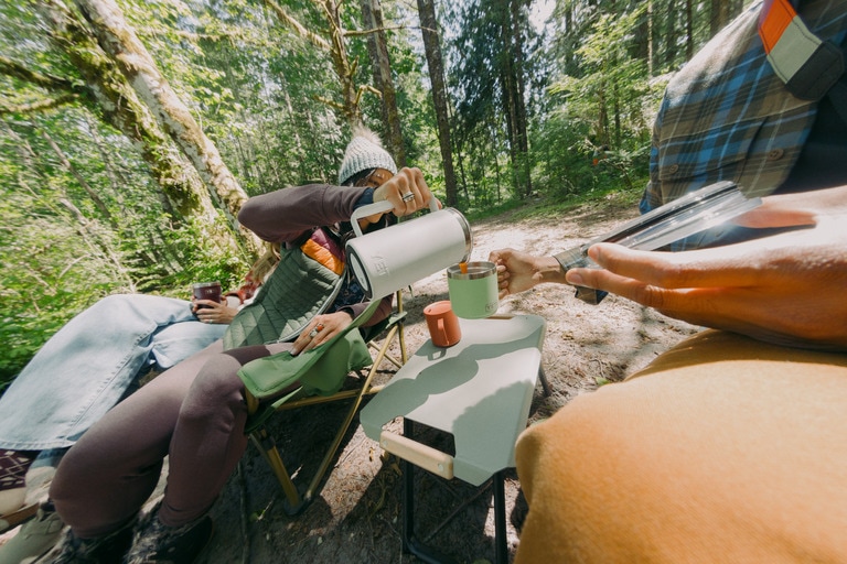 A camper pours coffee from a Yeti French Press