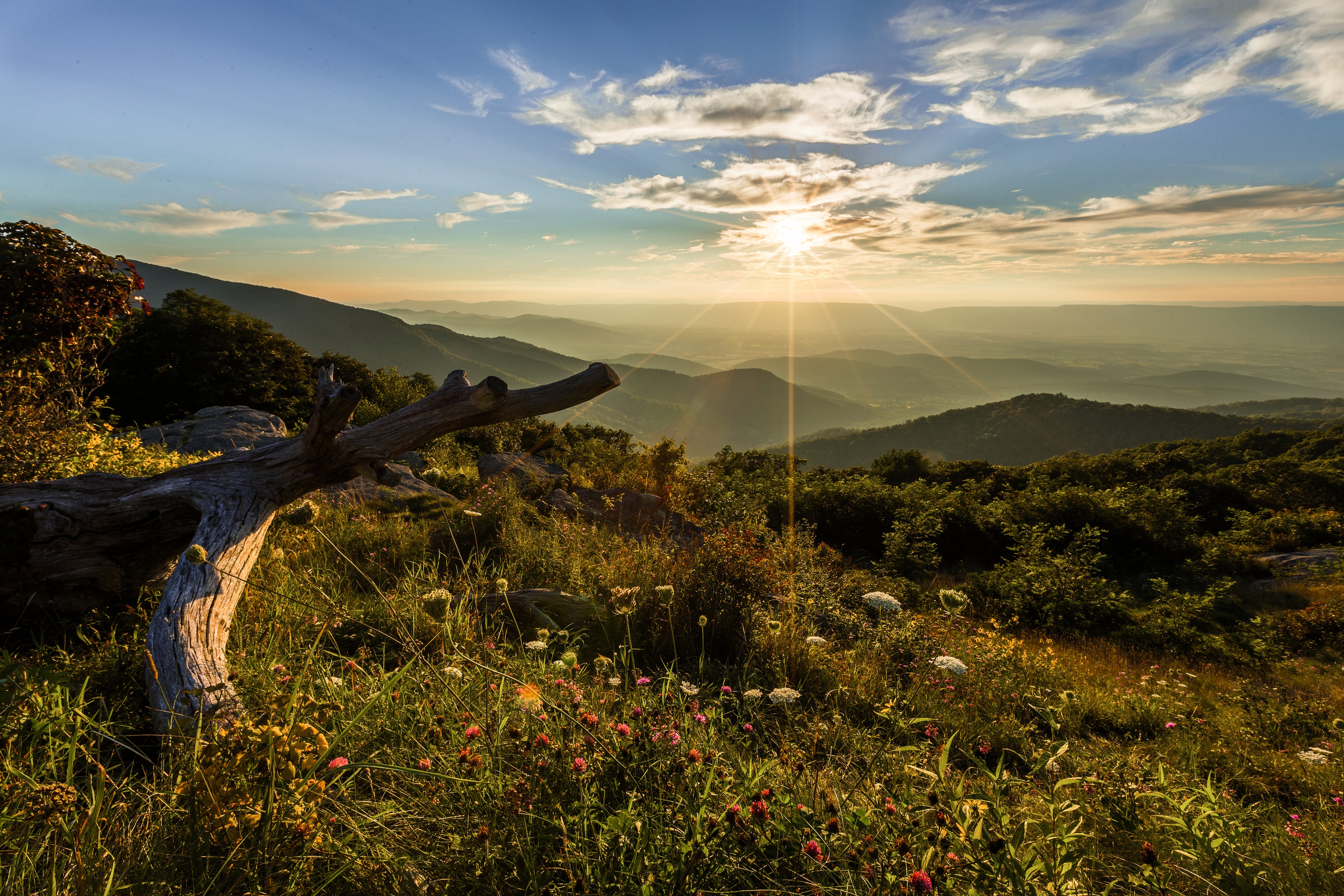 An image of a breathtaking sunset illuminates the peaks of a mountain range.