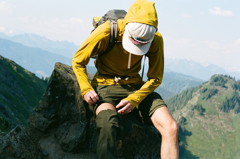 A person unzips the REI Co-op Sahara Convertible Pants