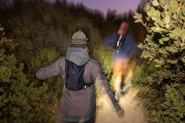 Two people running in the dark in winter running gear.