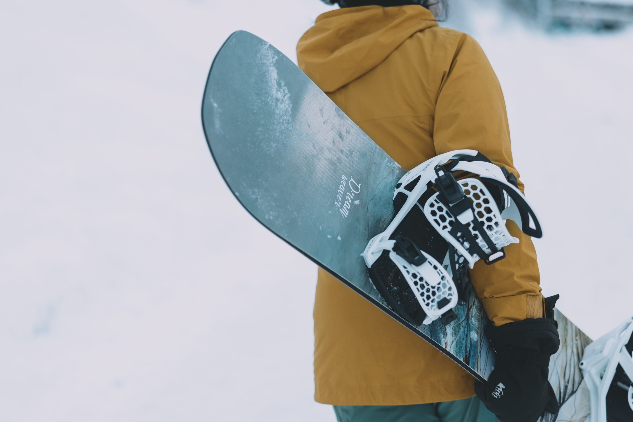 A person carries a snowboard at a ski resort