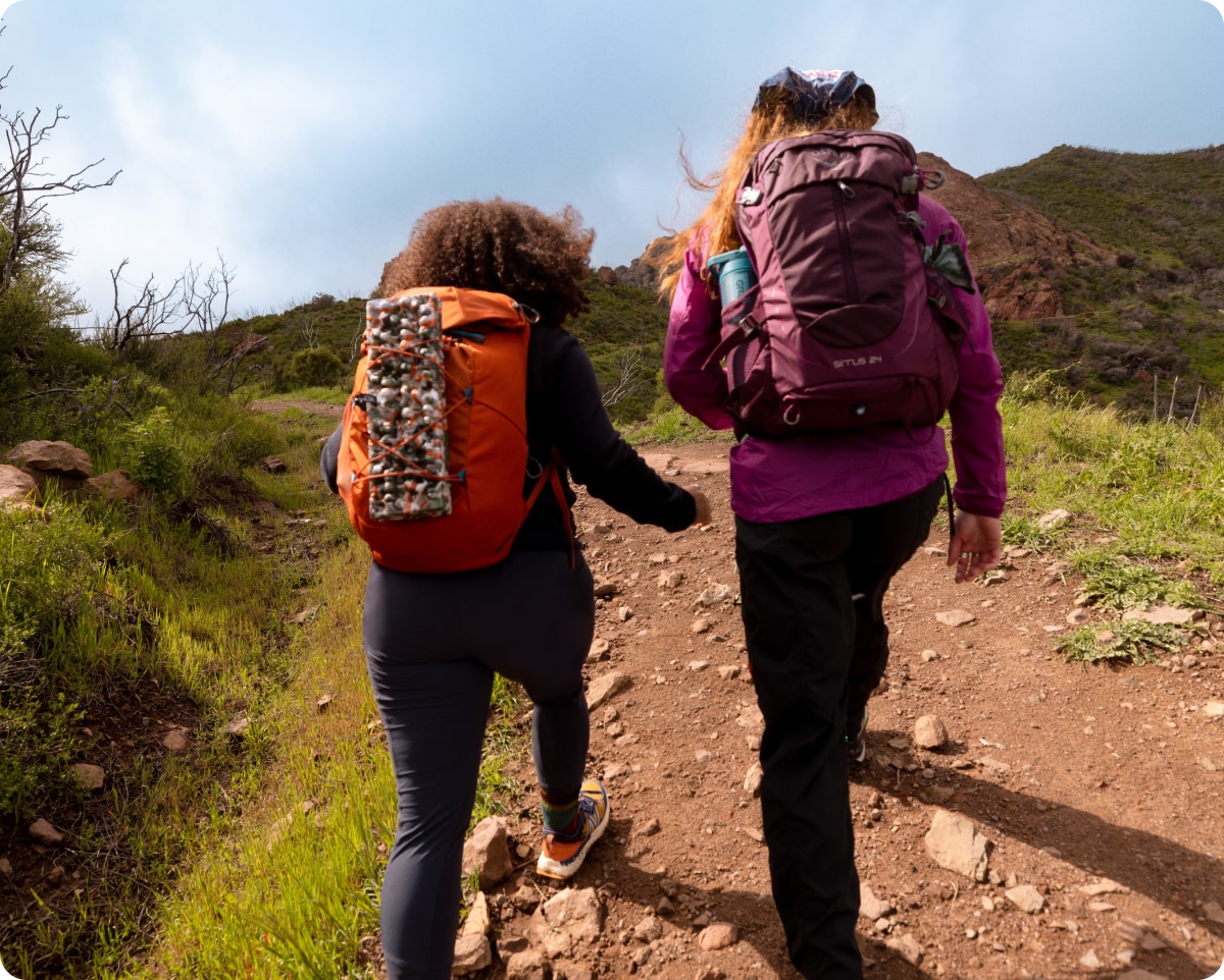 Two people hike up a rocky trail.