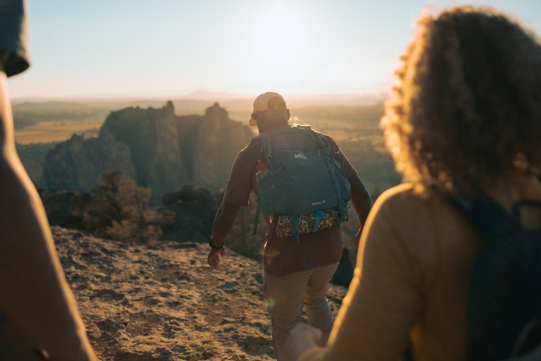 people walk in desert landscape in evening sunlight