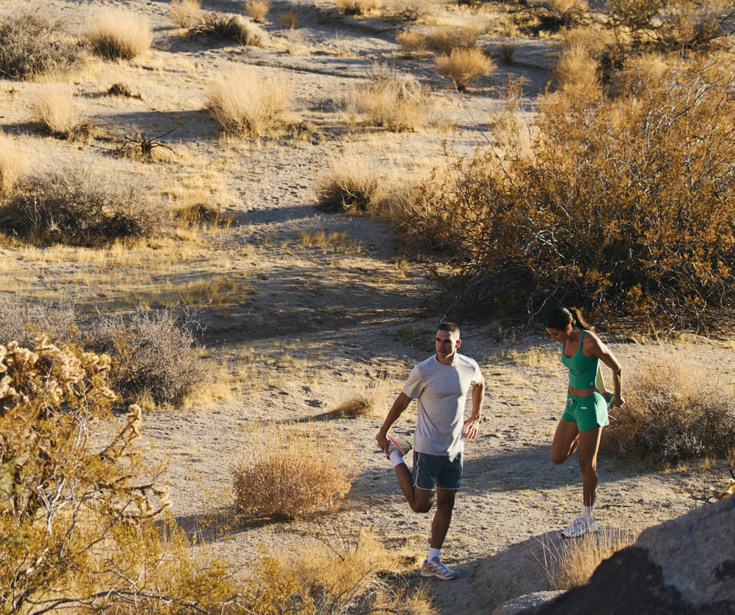 Two people take time to stretch before their trail run