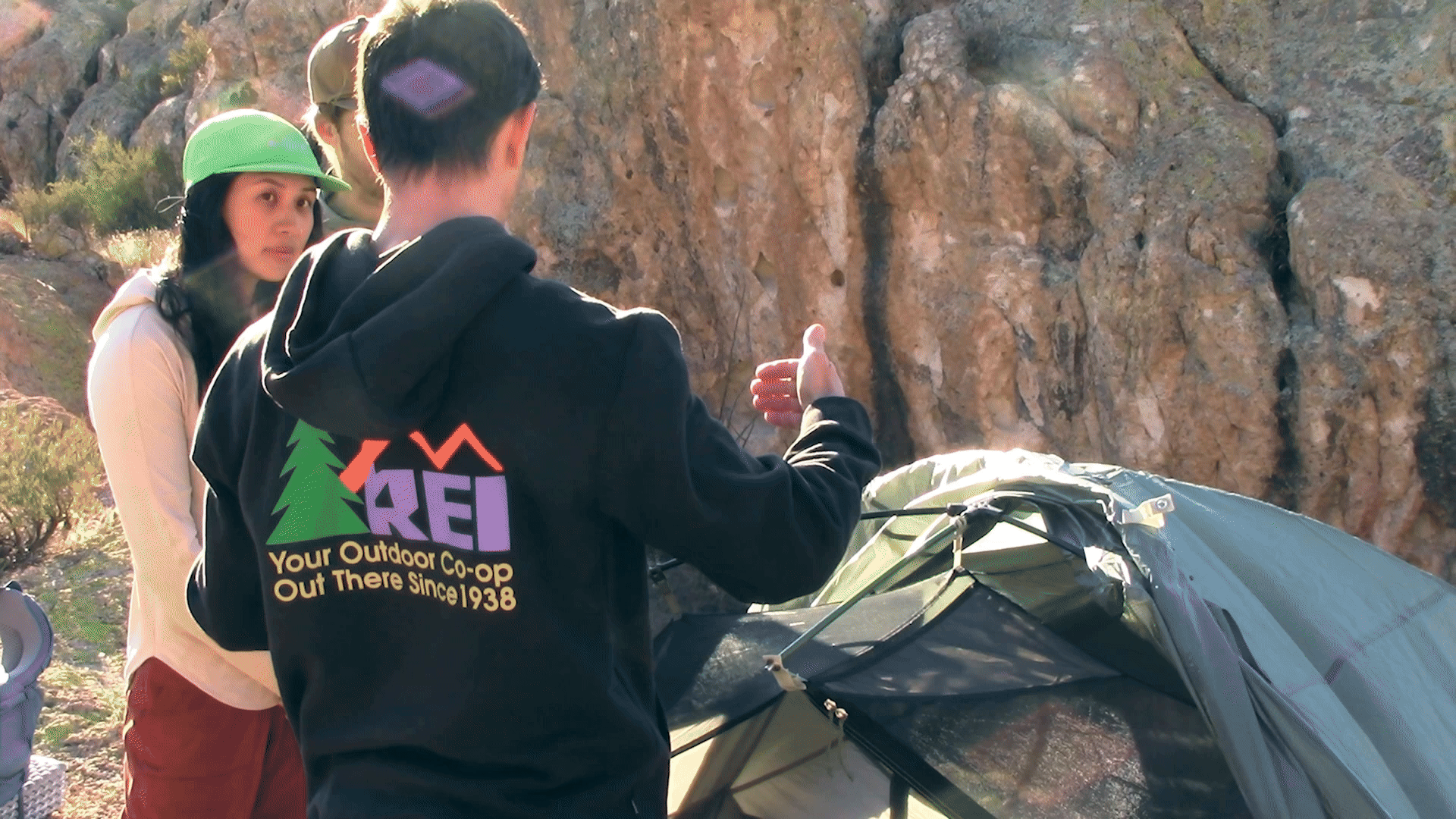 REI Coop brand tent with a user inside wearing a REI Coop brand sweater