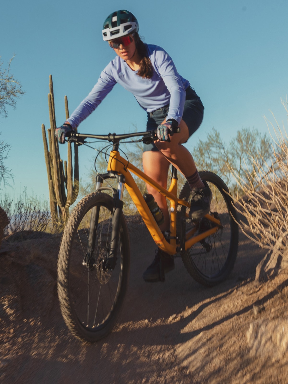 A person rides down a desert trail on their bike.