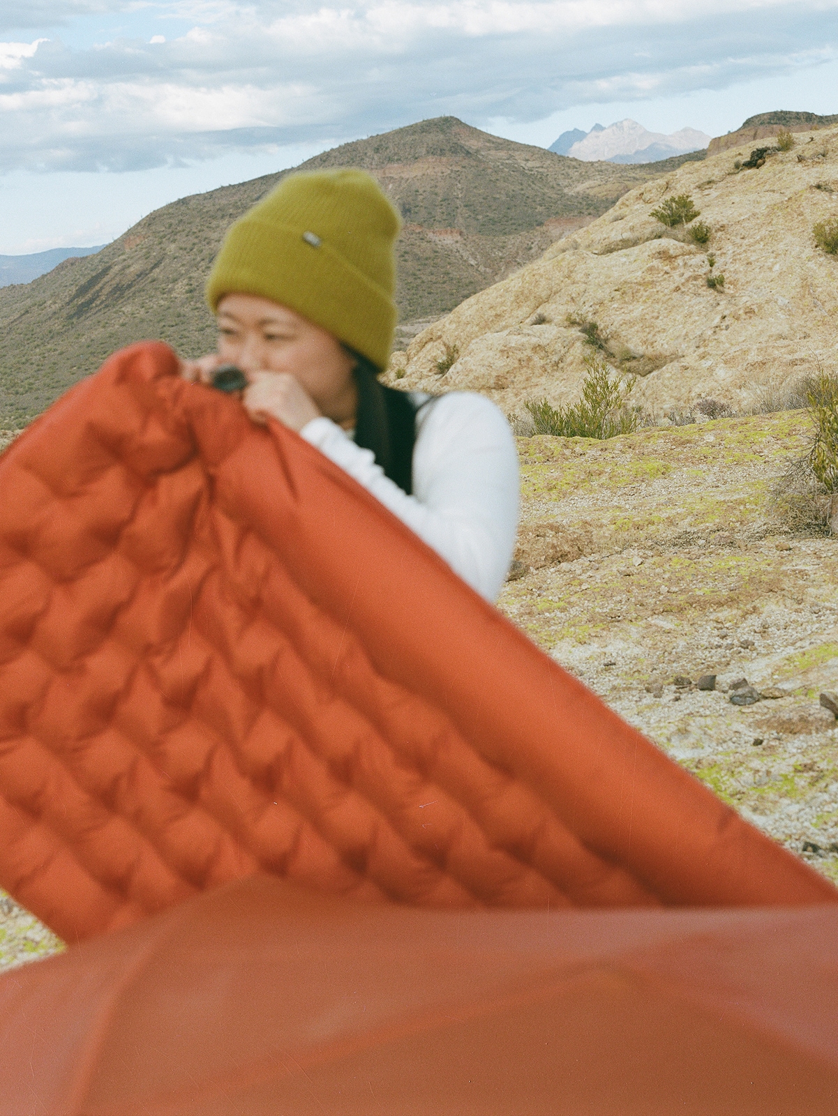 A person blows up their sleeping pad.