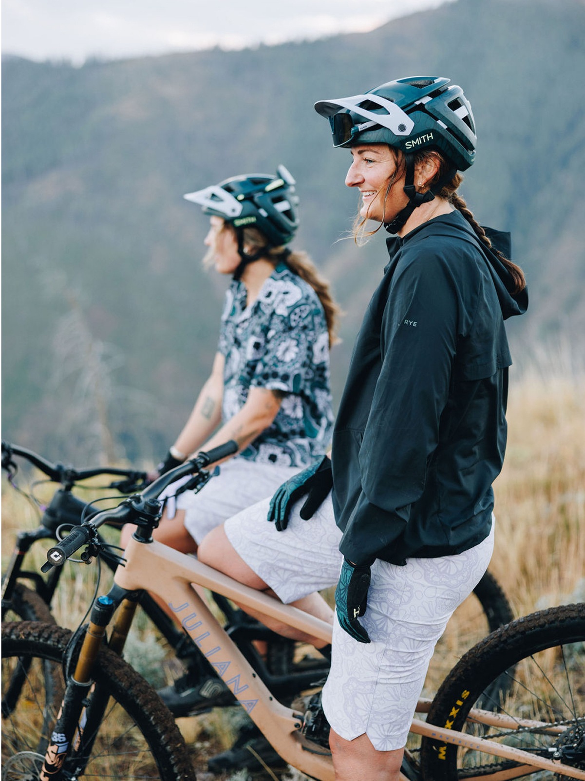Two people sit on their bikes while taking in the view.