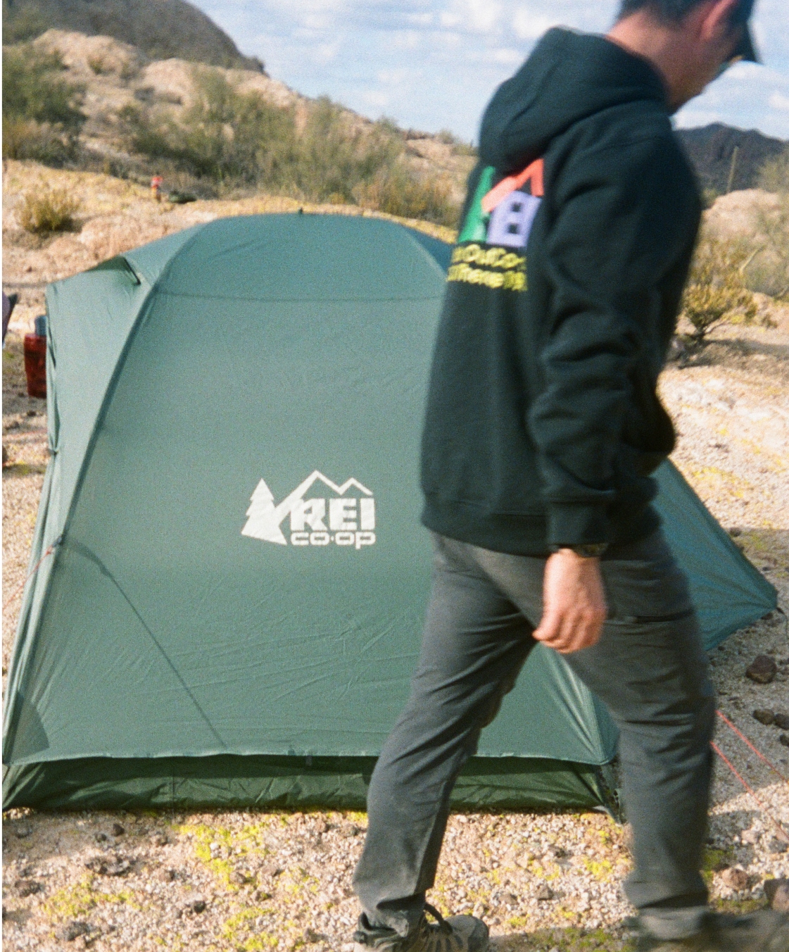A person walks in front of their R E I Co-op tent.