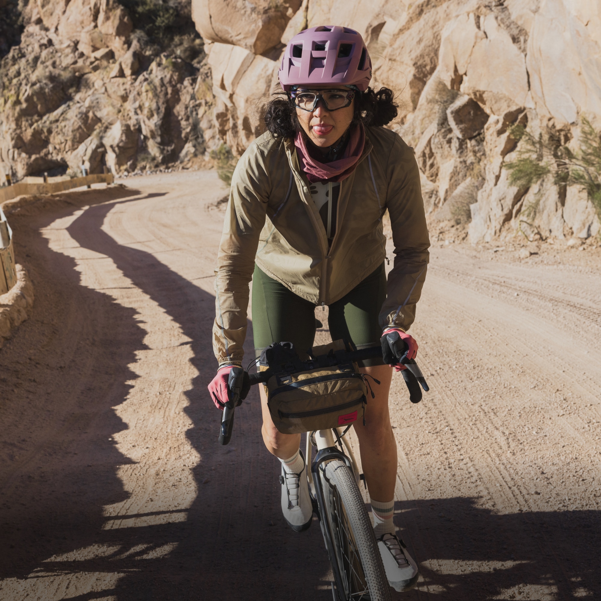 A person rides their bike up a rocky trail