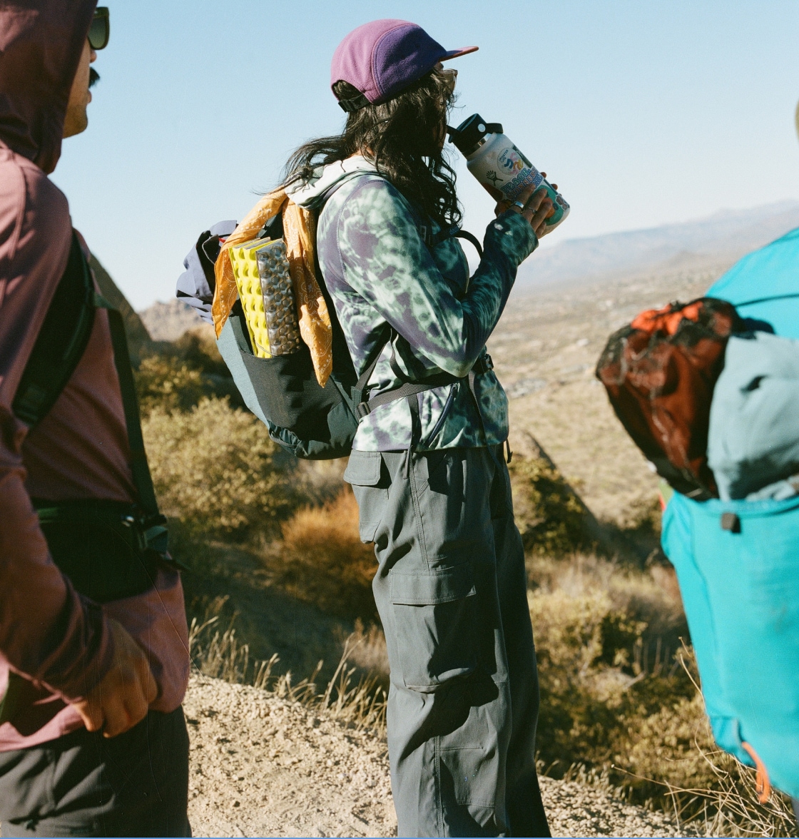 Two people looking off into the distance while they stop to take a break from hiking.