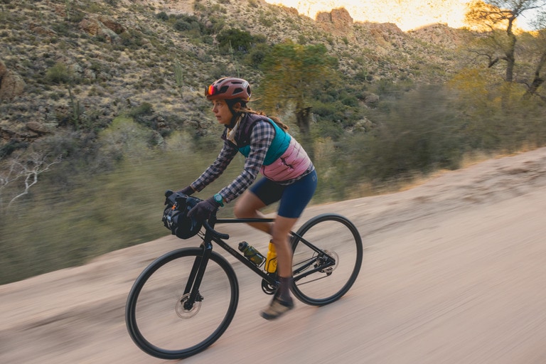 A woman riding a gravel bike on a trail