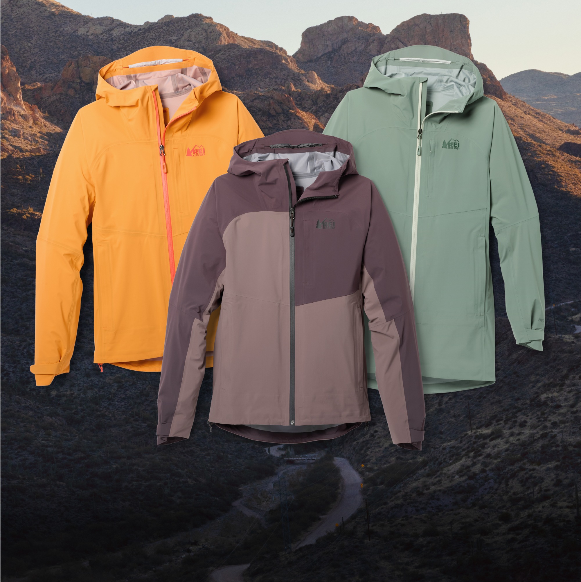 A collage of R E I Co-op rain jackets over an image of a rocky mountain range.