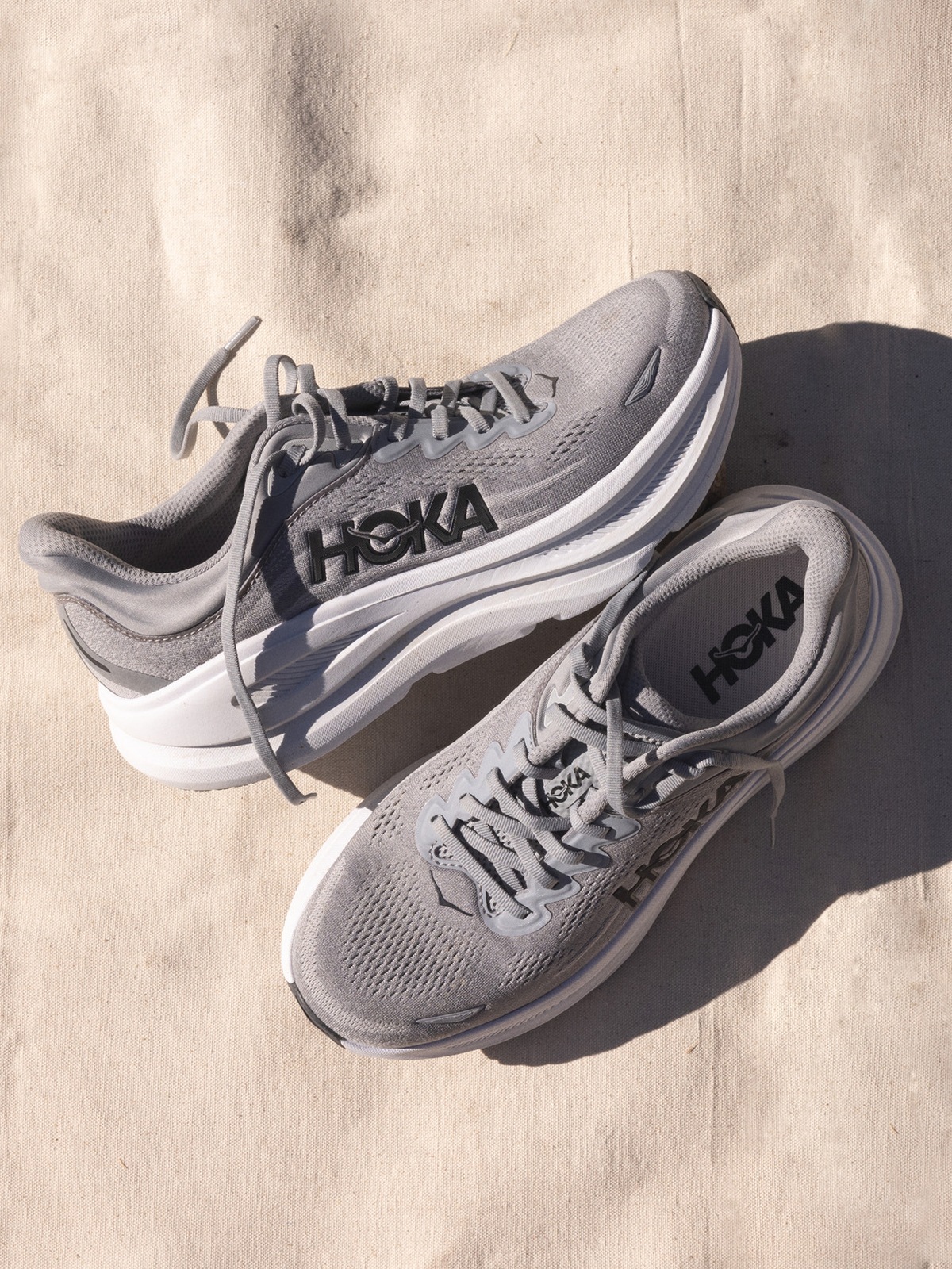 A pair of grey HOKA running shoes.