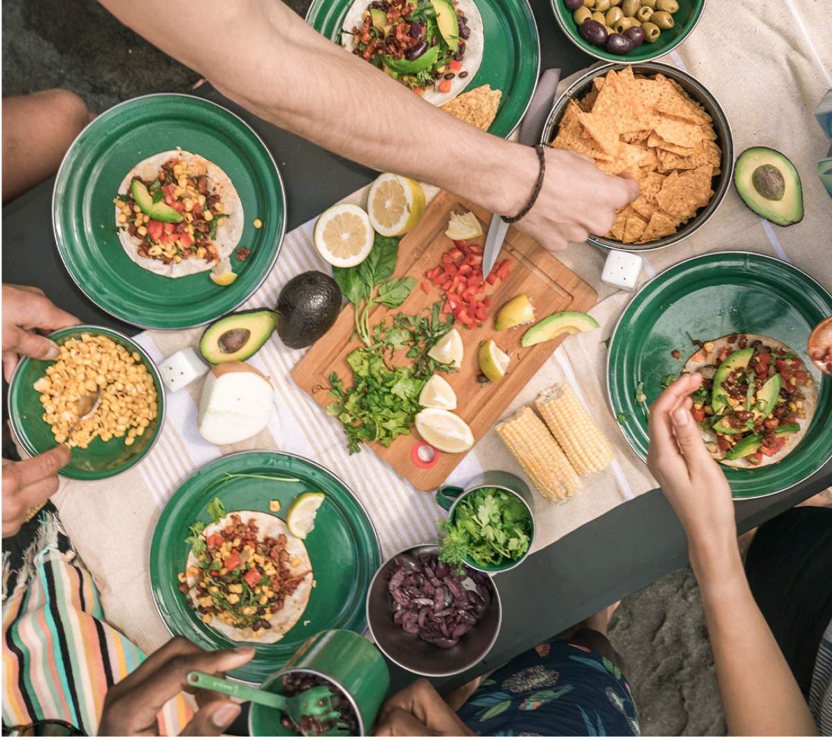 A group of people enjoying taco night at their campsite.
