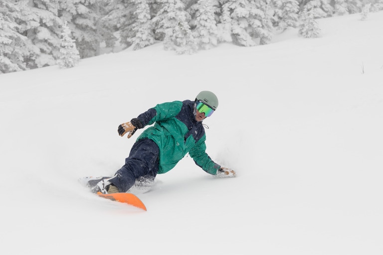 A snowboarder wears the REI Co-op Powderbound Anorak. 
