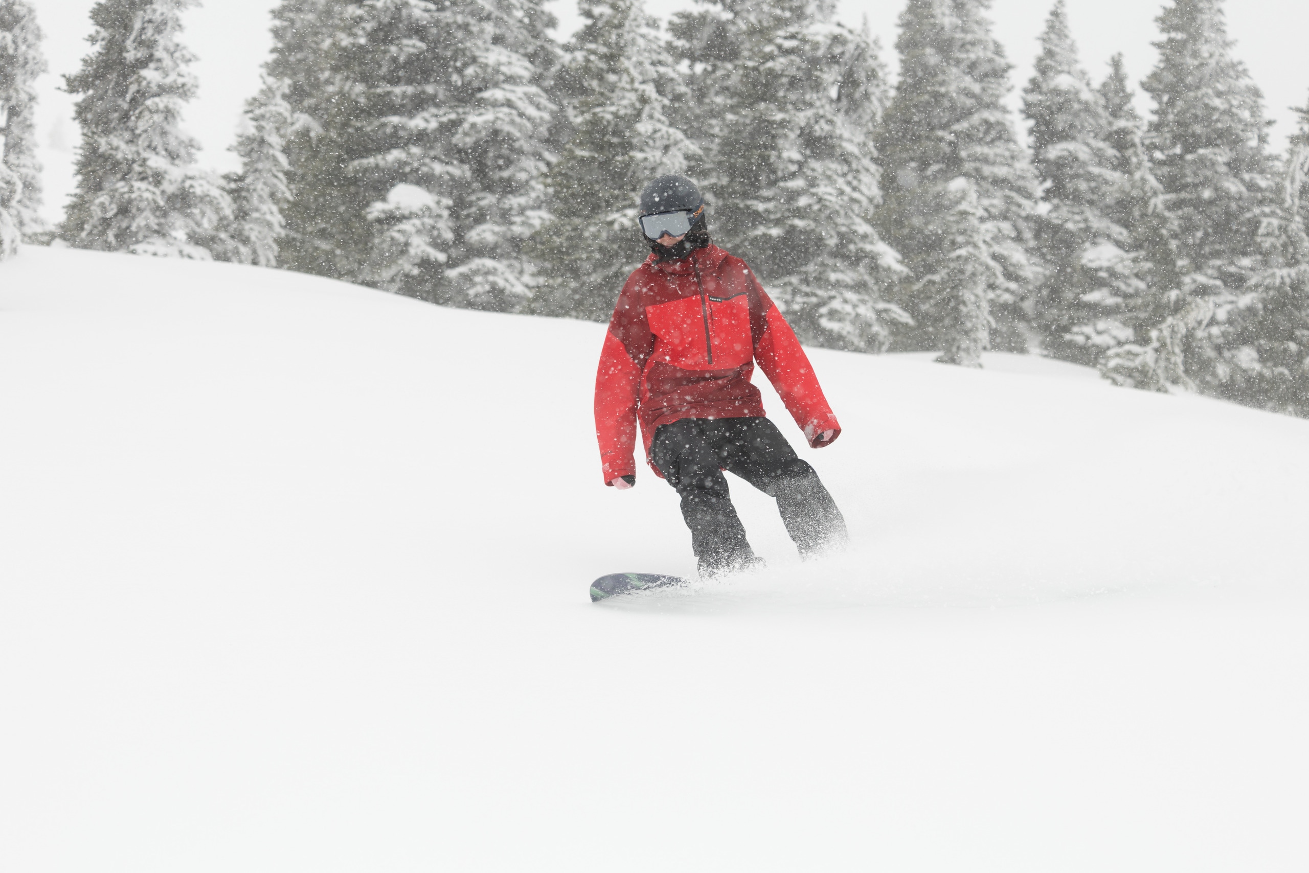 A person snowboards through powder at a ski resort
