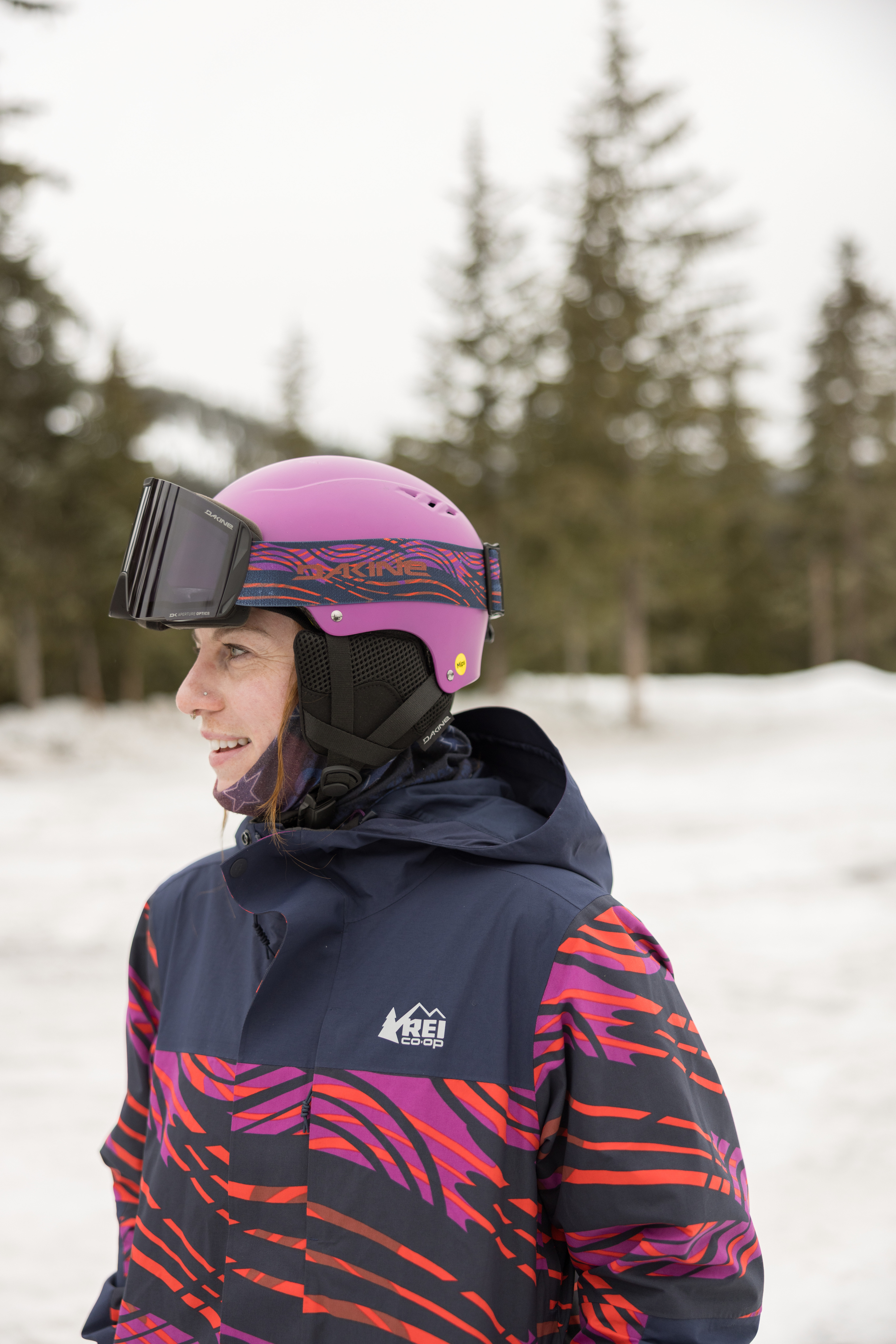 A woman wears a snow helmet with snow goggles.
