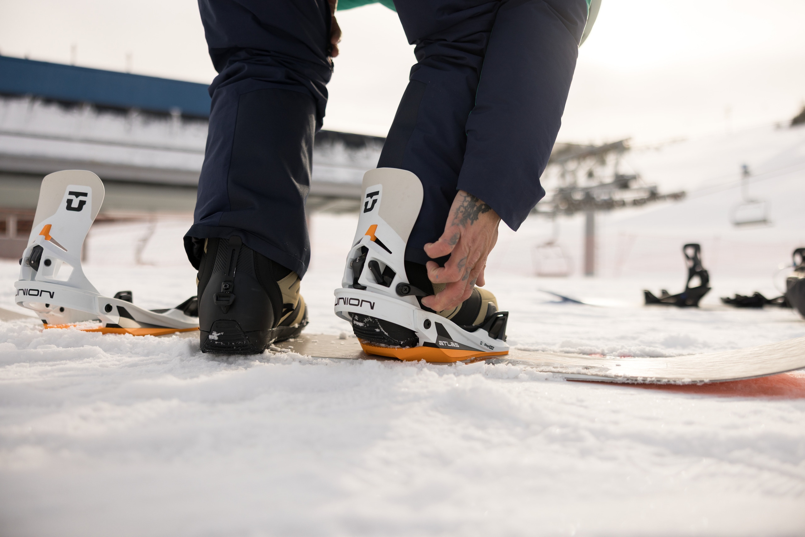 A snowboarder gets ready to ride using step-in bindings