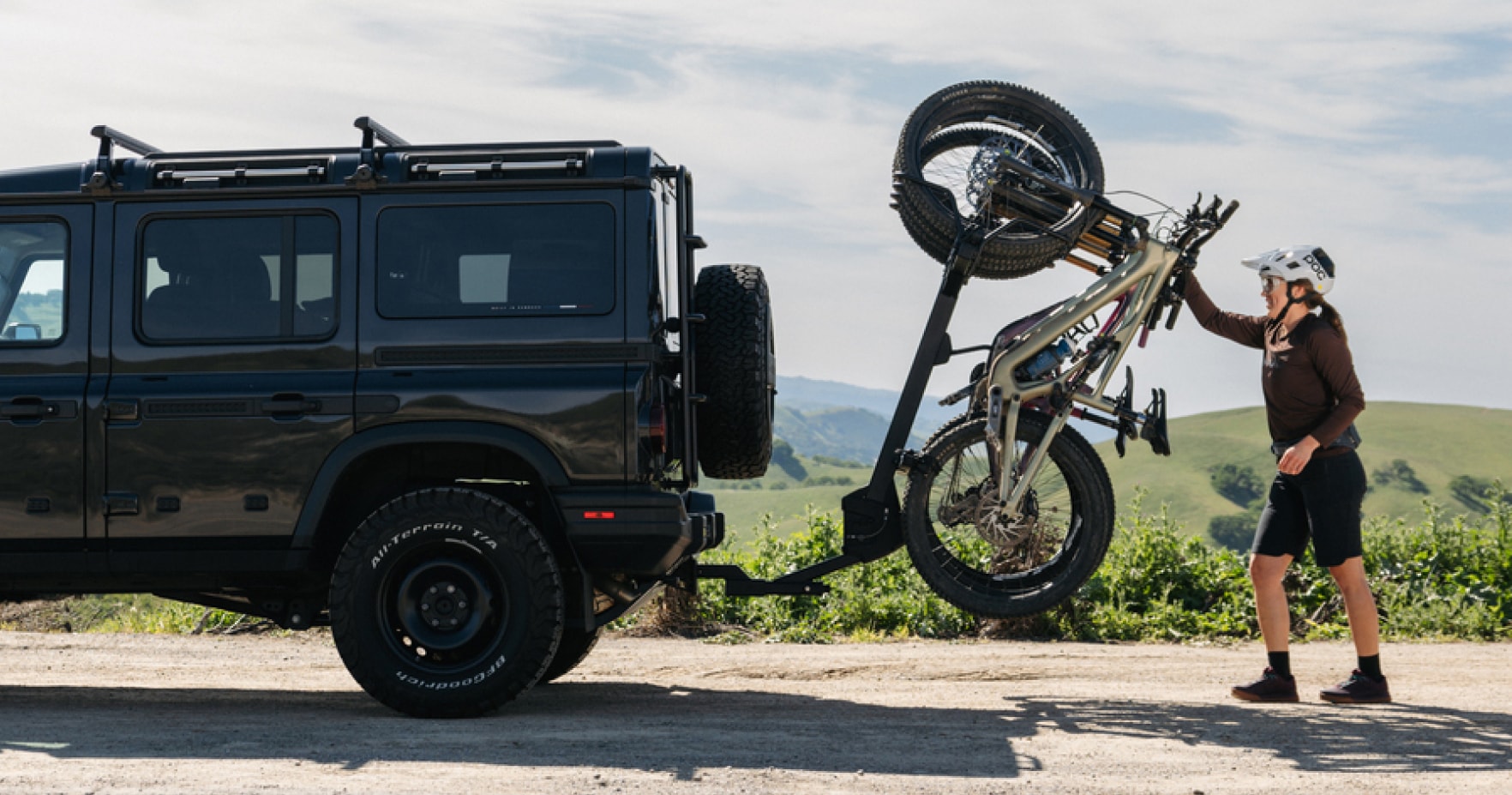 A person gets ready to unload their bike from their car rack.