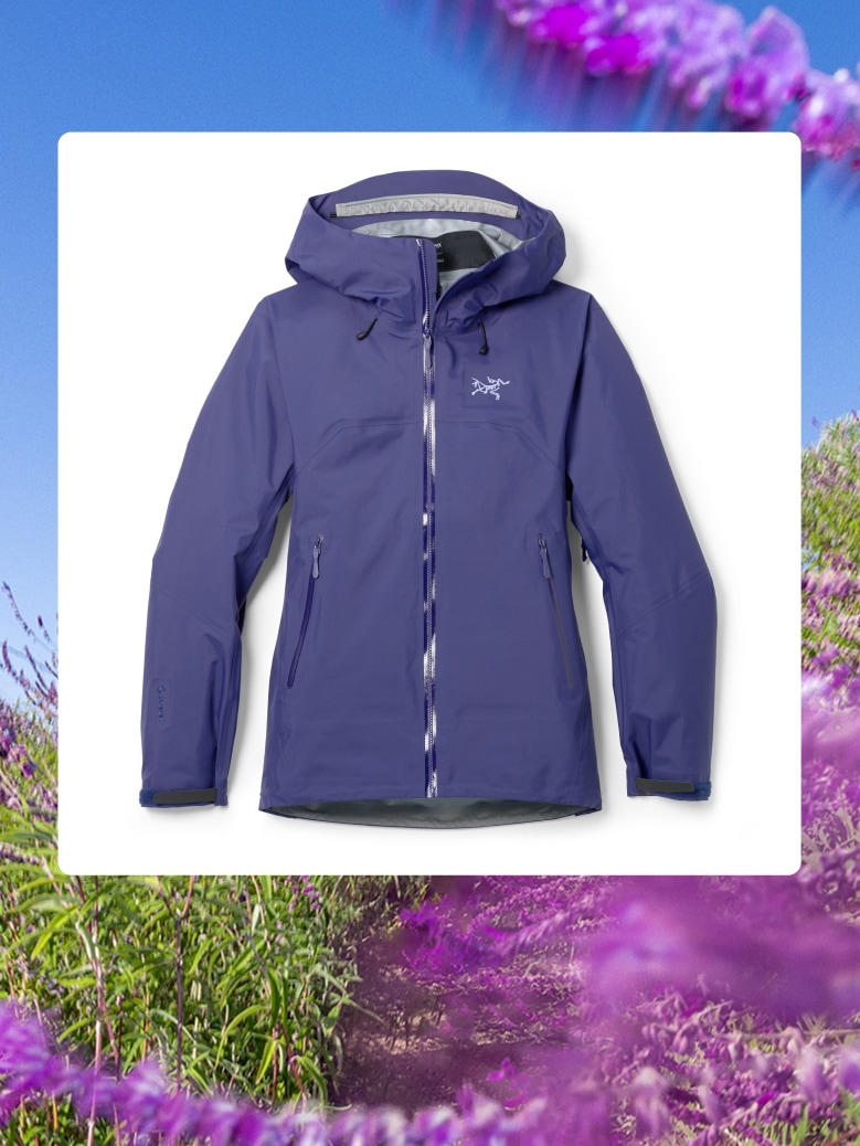 A women’s Arc’teryx Beta SL jacket over an image of purple flowers.