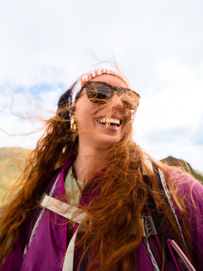 A person laughs for the camera on a windy day.