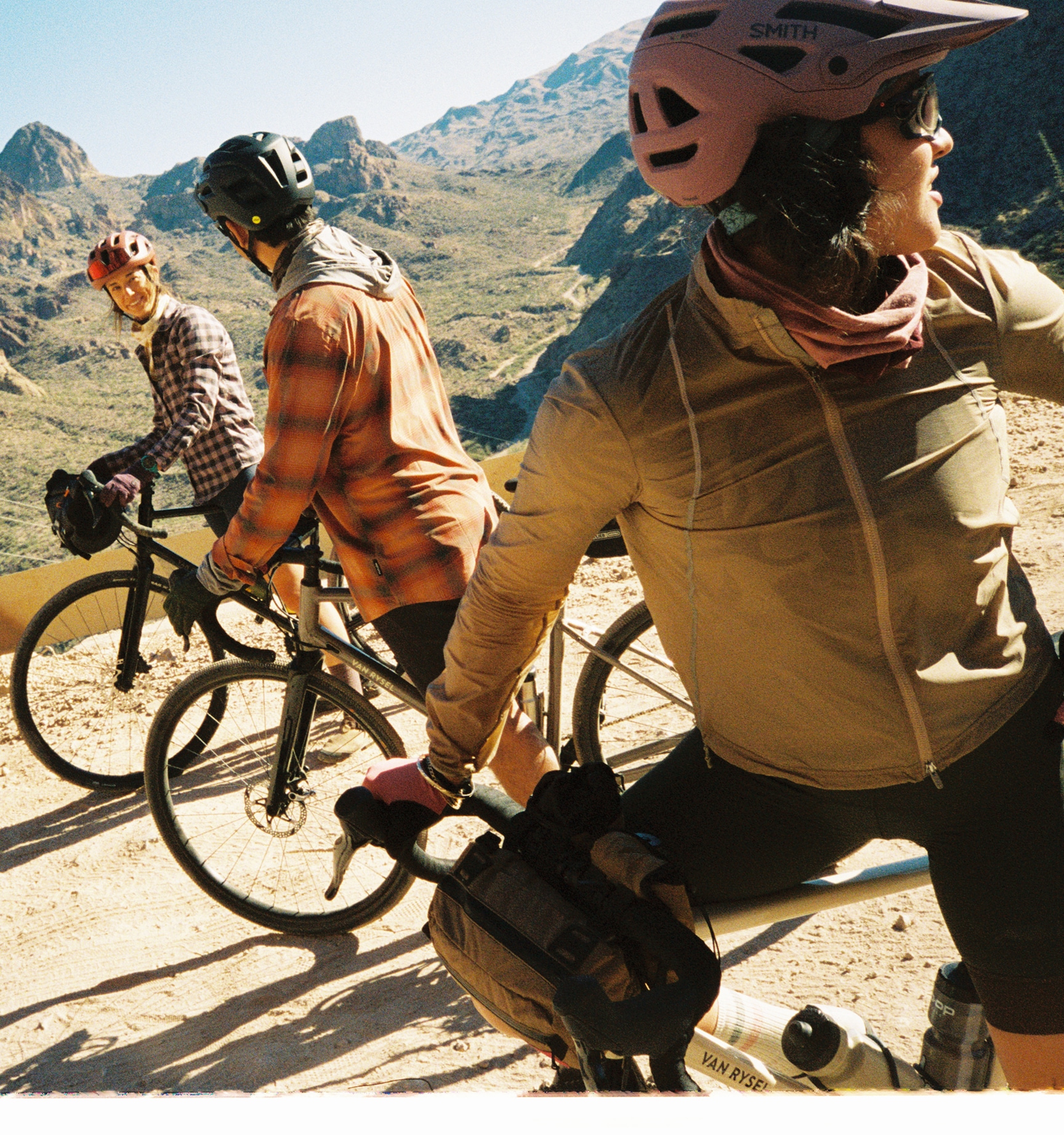A group of cyclists ride down a mountain trail.