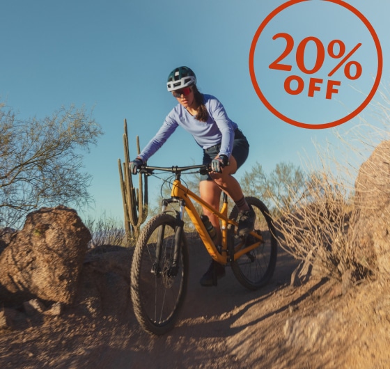 A person rides down a desert trail on their bike.