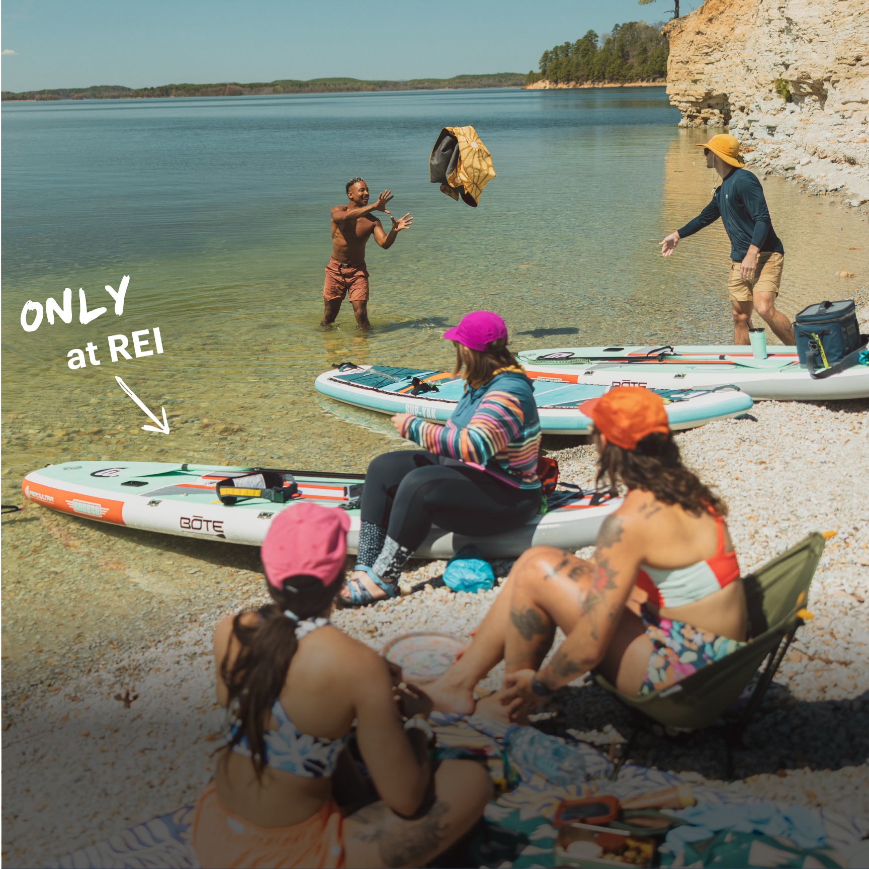 A group of people prepare to take their paddle boards out on the lake.