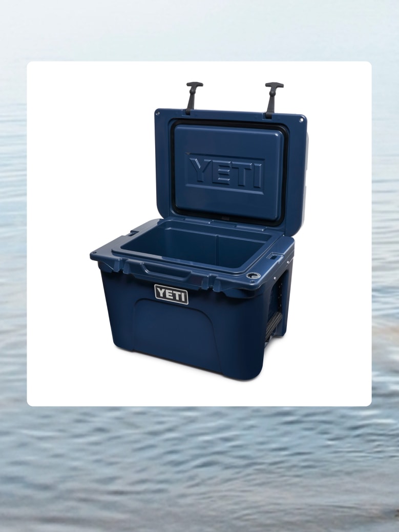 A navy blue YETI cooler over an image of water.