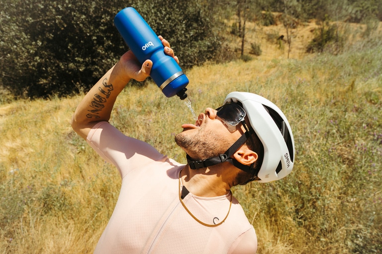 A cyclist drinking from a water bottle