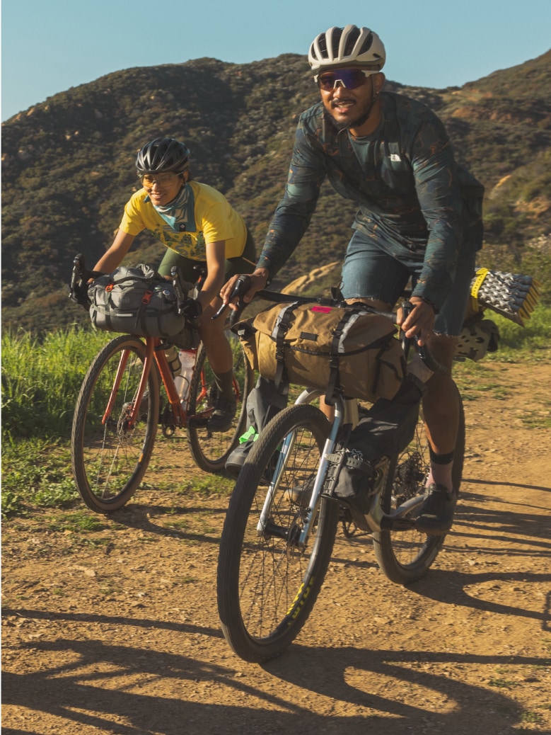 People bike through a desert trail.