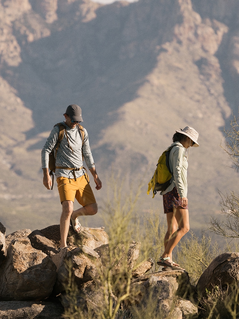 Two people hike through a rocky path.