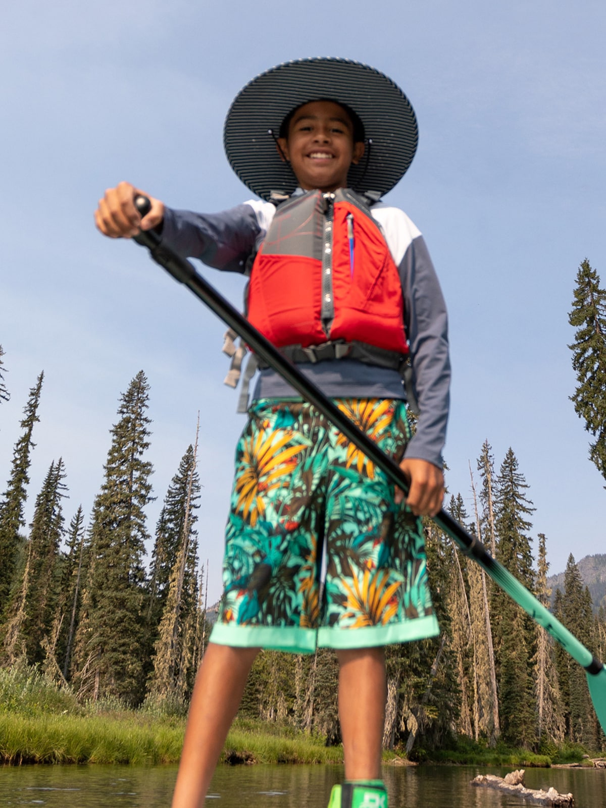 A person on a paddle board smiles for the camera.