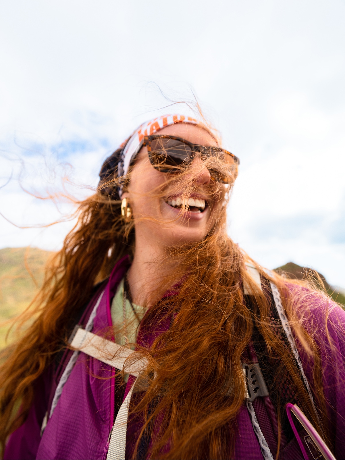 A person laughs for the camera on a windy day.