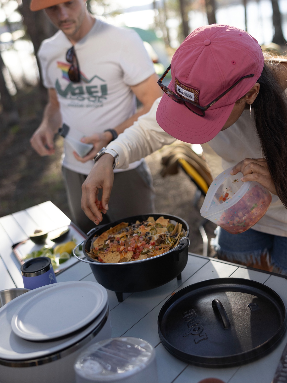 A person makes nachos at their campsite.