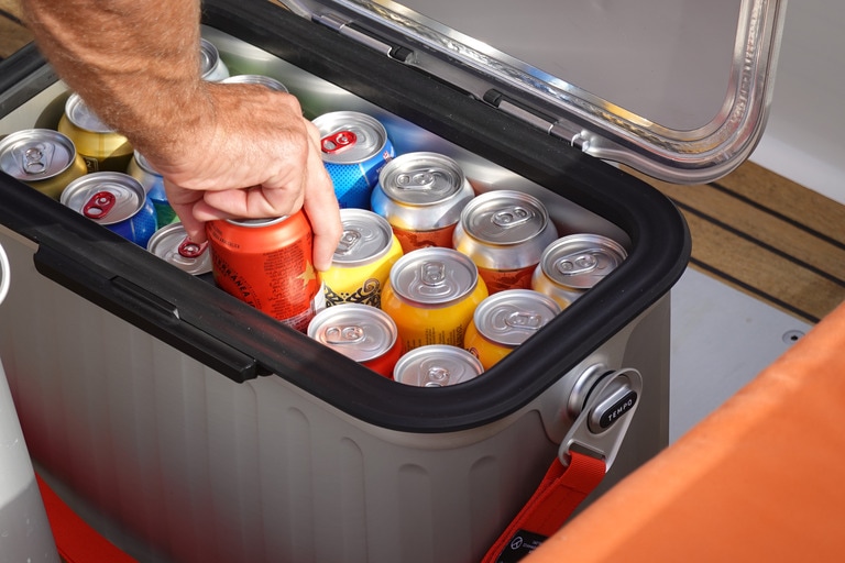 Picture of an open Oyster cooler with at least 18 canned beverages inside.