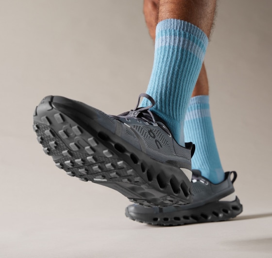 A person shows off their On Cloudsurfer Trail 2 shoe for the camera.