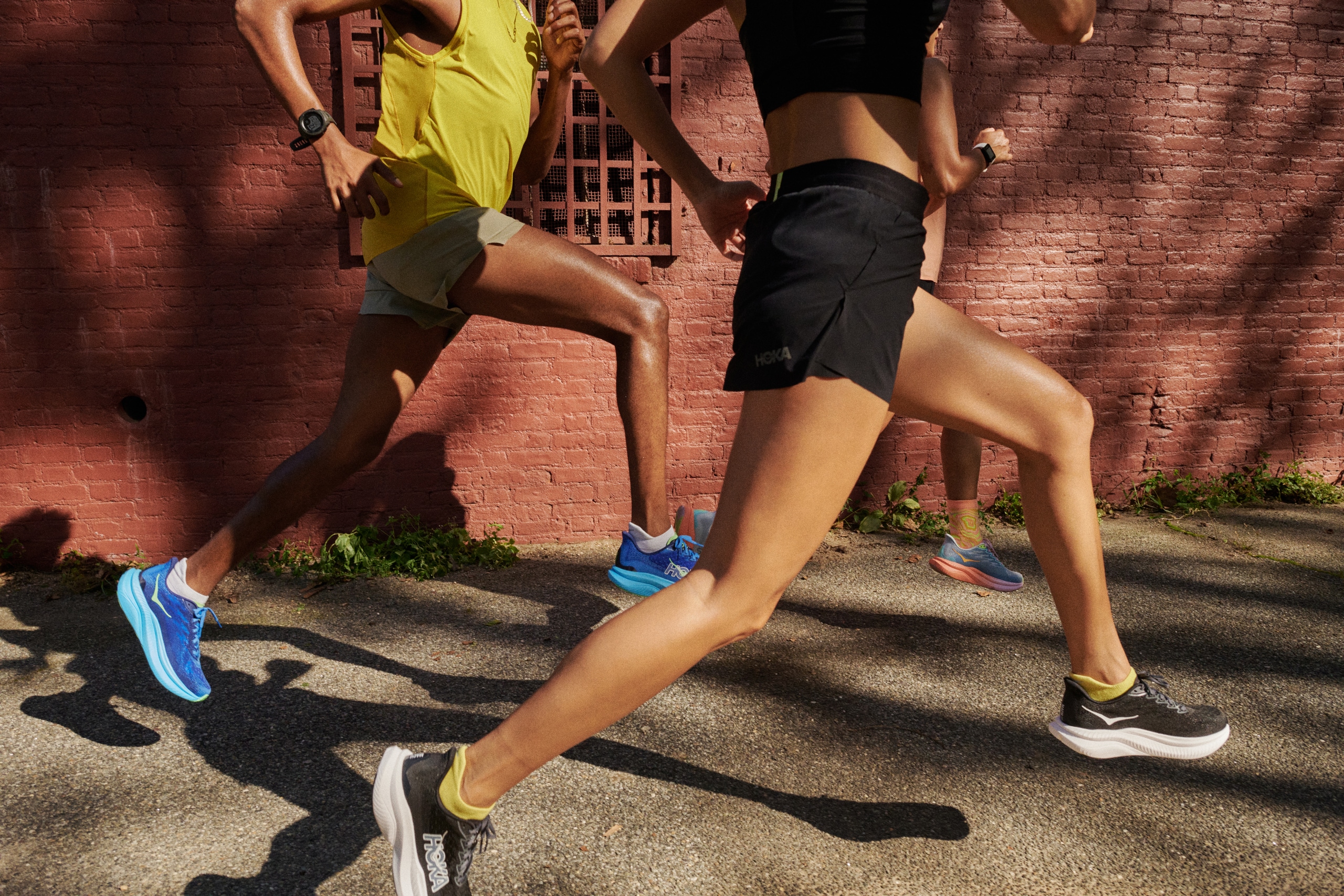 A below the neck view of two people running in the HOKA Mach 6 road-runnign shoes